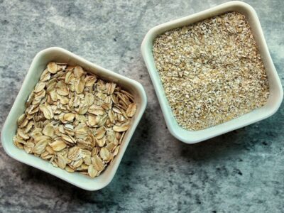 Raw rolled oats and oat bran in white, glass containers.