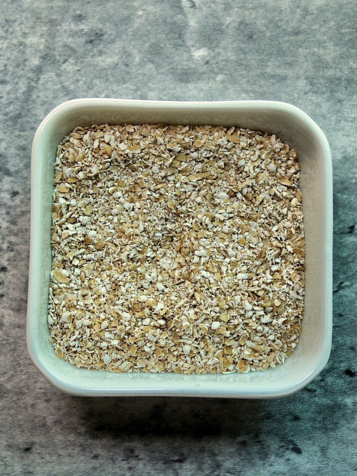 Oat bran in a white glass bowl. 
