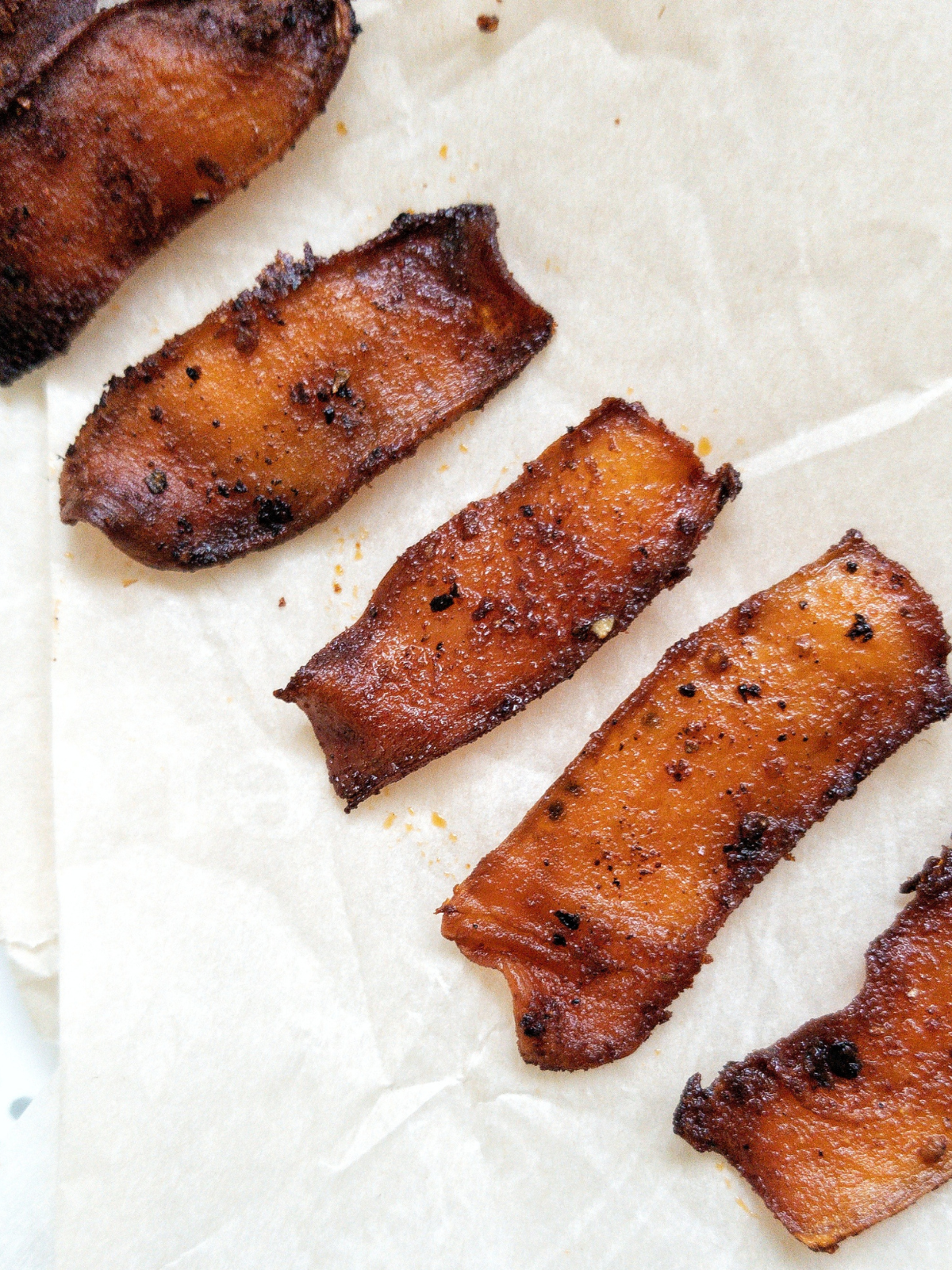 Cooked oyster mushroom bacon on parchment paper. 