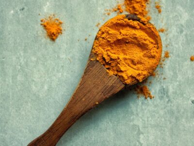 Turmeric powder on a wooden spoon.