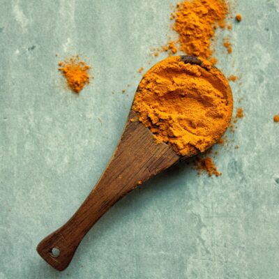 Turmeric powder on a wooden spoon.