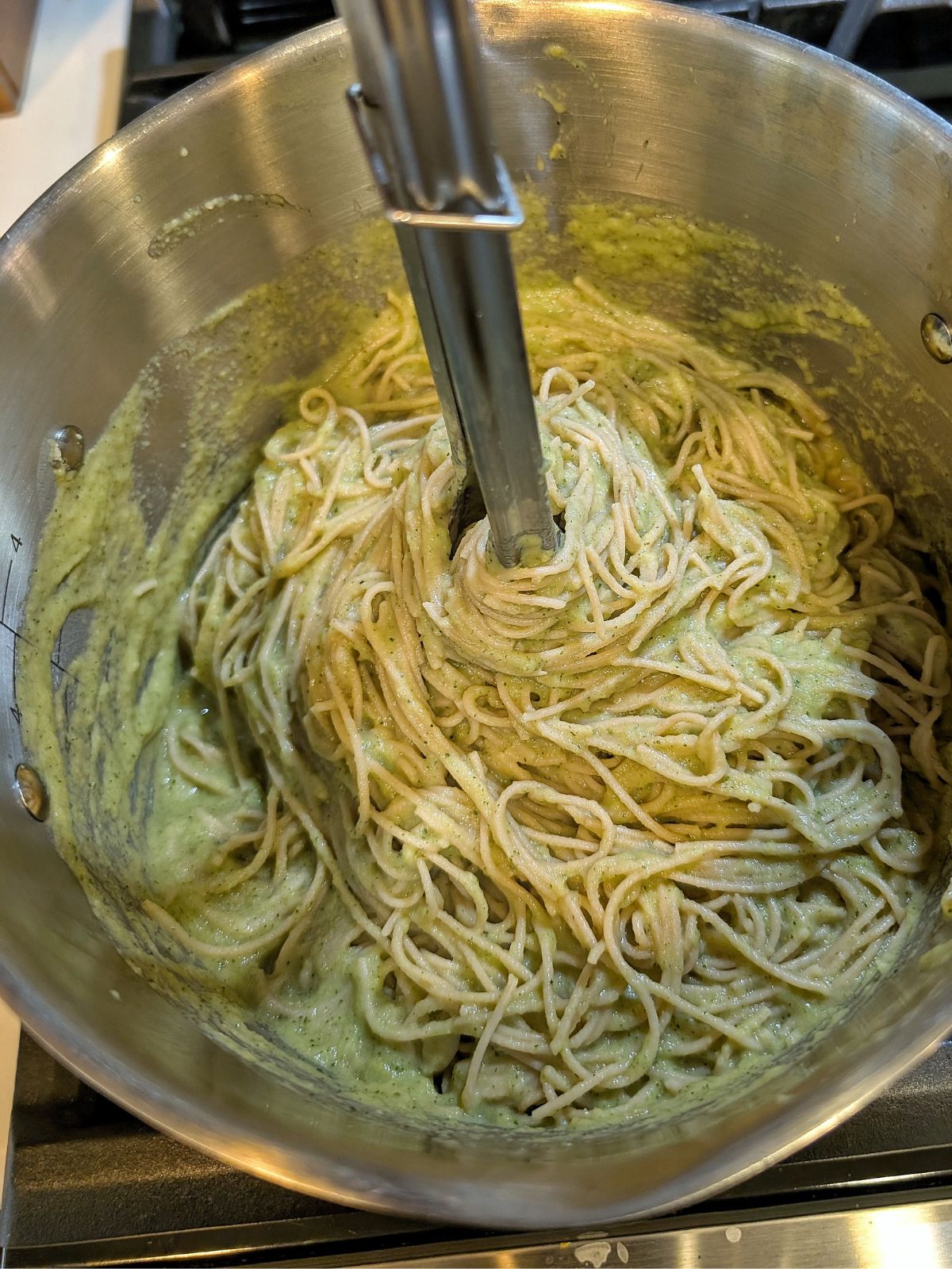 A large pot with whole wheat pasta with zucchini pasta sauce. 