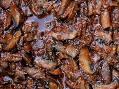 Closeup of cooked mushrooms in a sauce.