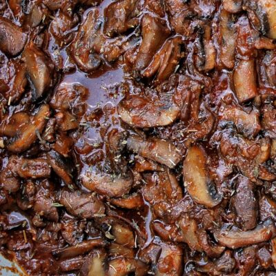 Closeup of cooked mushrooms in a sauce.