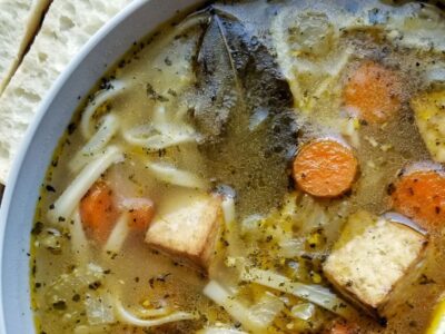 Bowl of tofu noodle soup with carrots.