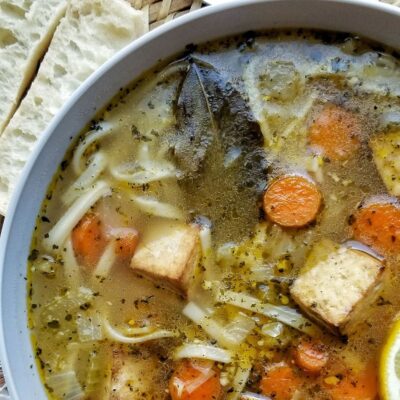 Bowl of tofu noodle soup with carrots.